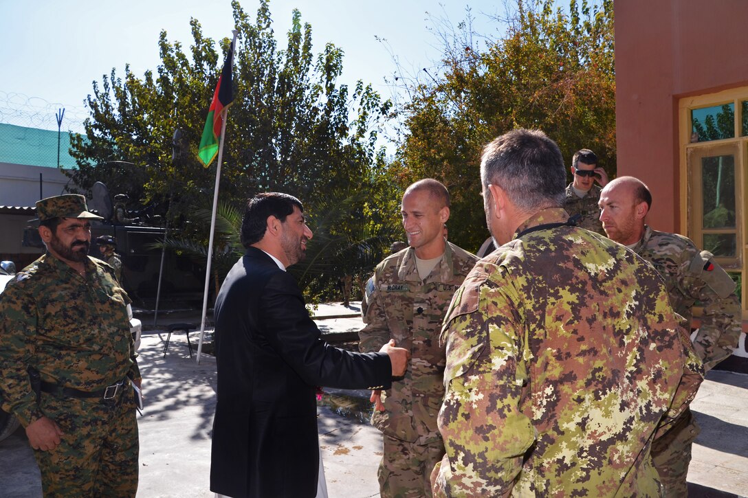 Dr. Mohammad Akram Khpalwak, provincial governor of Farah province, greets U.S. Navy Cmdr. Louis McCray before a key leader engagement in Farah City, Afghanistan, Nov. 12, 2012. McCray commands Provincial Reconstruction Team Farah.