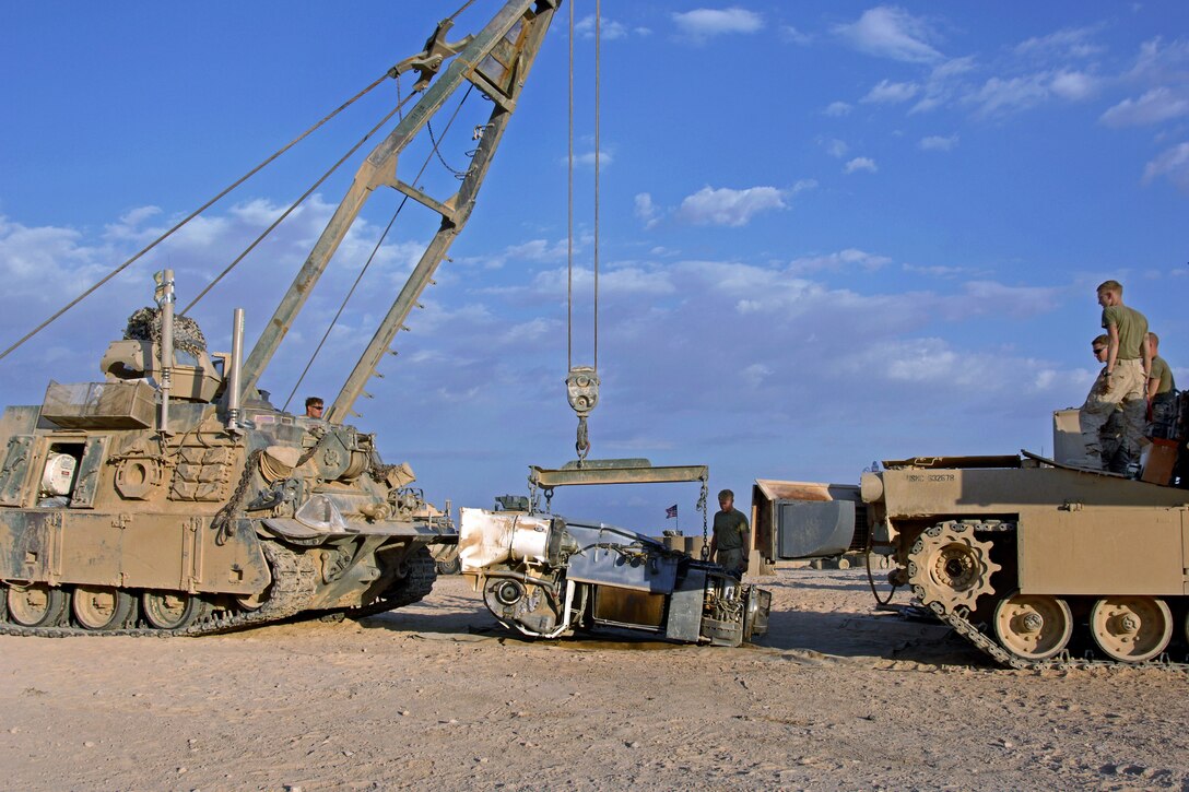 U.S. Marines use an M88A2 Hercules armored recovery vehicle to reinstall the engine into an M1A1 Abrams tank on Combat Outpost Shir Gazay in Afghanistan's Helmand province, Nov. 4, 2012. The Marines are mechanics assigned to Bravo Company, 2nd Tank Battalion. The mechanics can rapidly replace a malfunctioning engine to ensure continued mission readiness.
