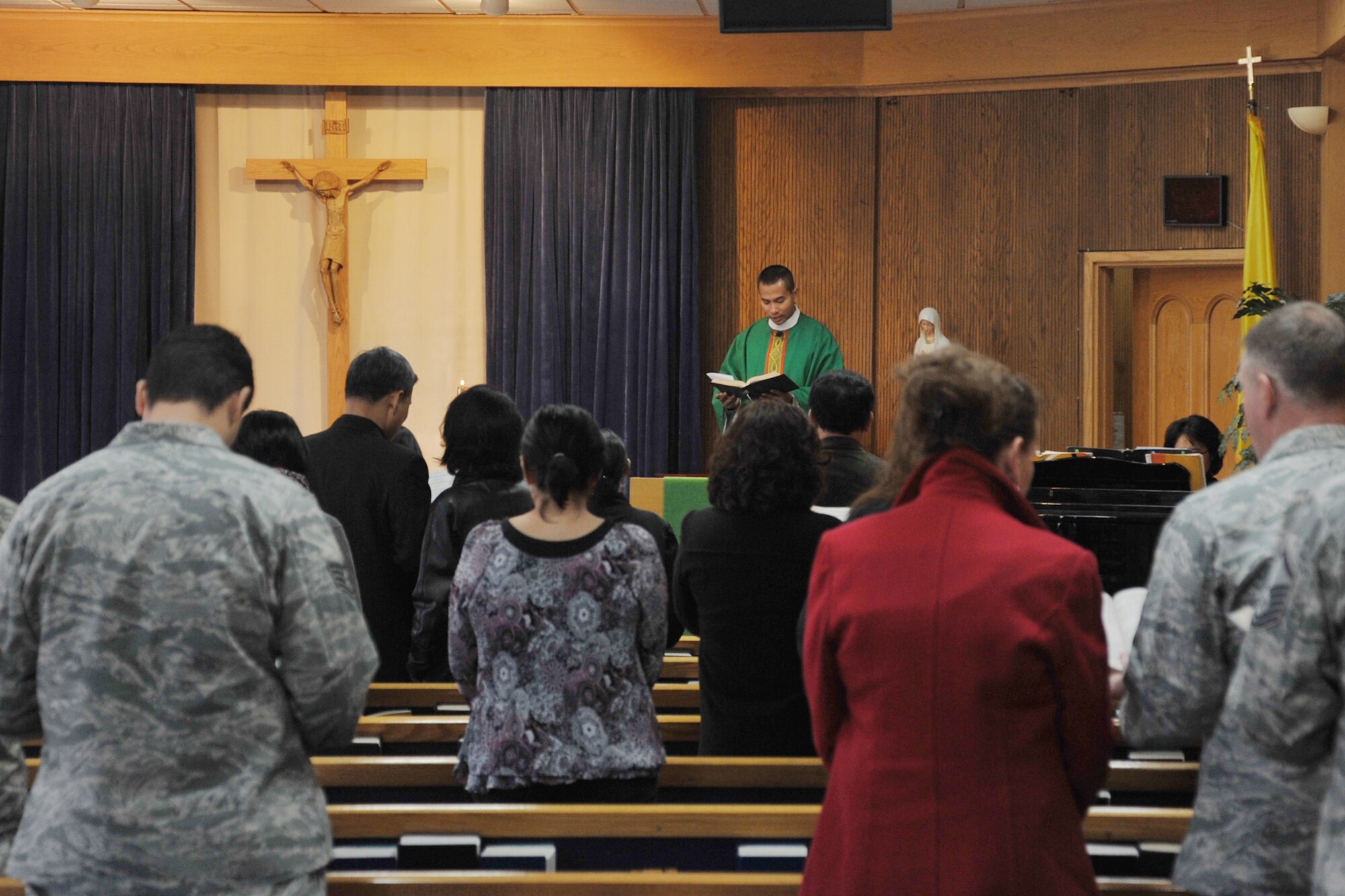 Chaplain (Capt.) Hoang Nguyen, 51st Fighter Wing Catholic chaplain, leads a memorial service for Yi, Un Sop, also known as Mr. Tadu, at Osan Air Base, Republic of Korea, Nov. 14, 2012. Friends and family gathered for the event to honor his 60 years of dedicated service to the Osan community. (U.S. Air Force photo/Staff Sgt. Craig Cisek)