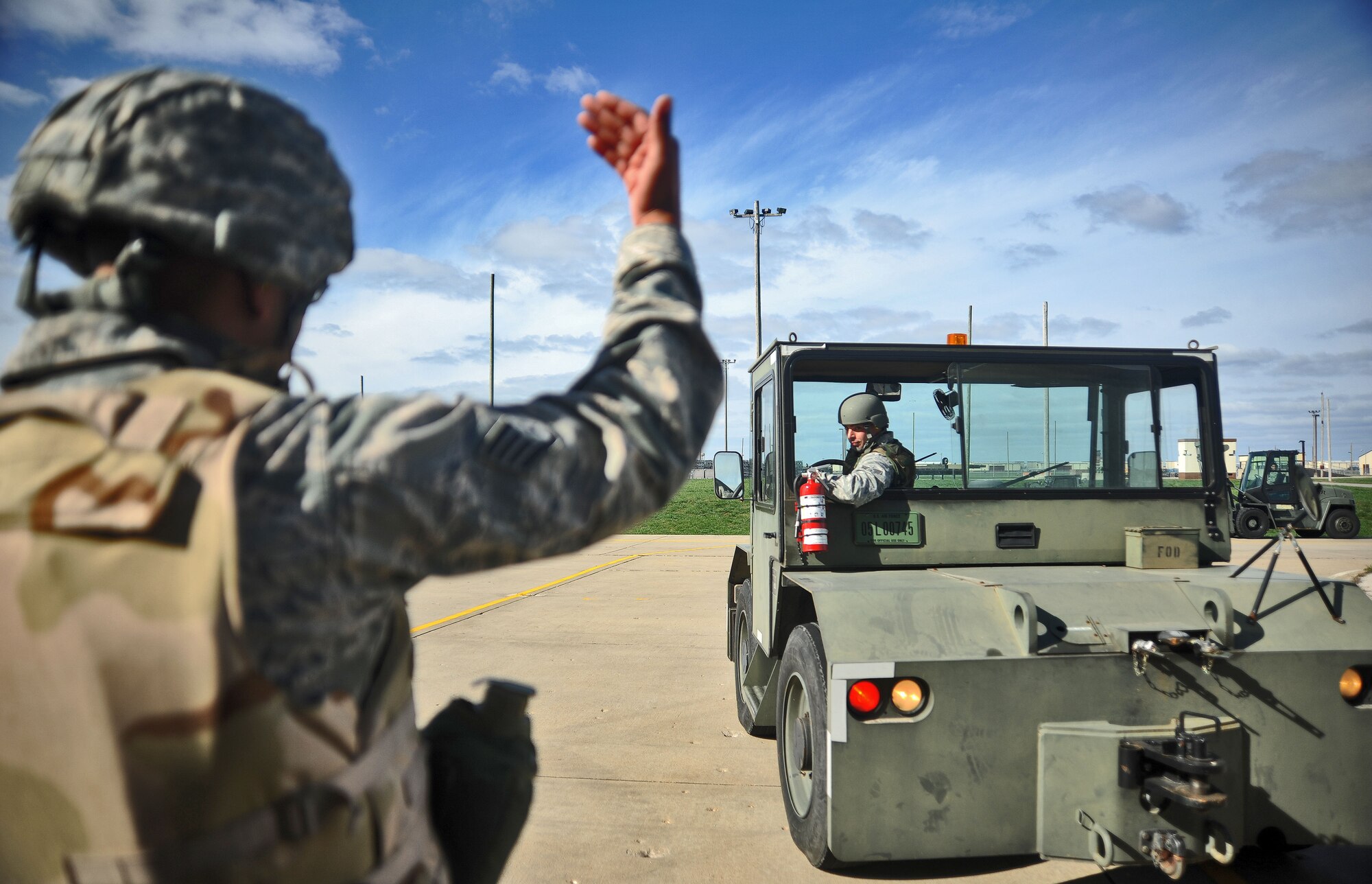 WHITEMAN AIR FORCE BASE, Mo. -- Staff Sgt. Tyler Campbell, 509th Munitions Support Squadron line delivery crew chief, spots Senior Airman Keith Durham as Durham backs in his weapons-tow vehicle Oct. 26. Having a spotter saves the Air Force money of by preventing vehicle collisions and damage to government property. (U.S. Air Force photo/Senior Airman Nick Wilson) (Released)