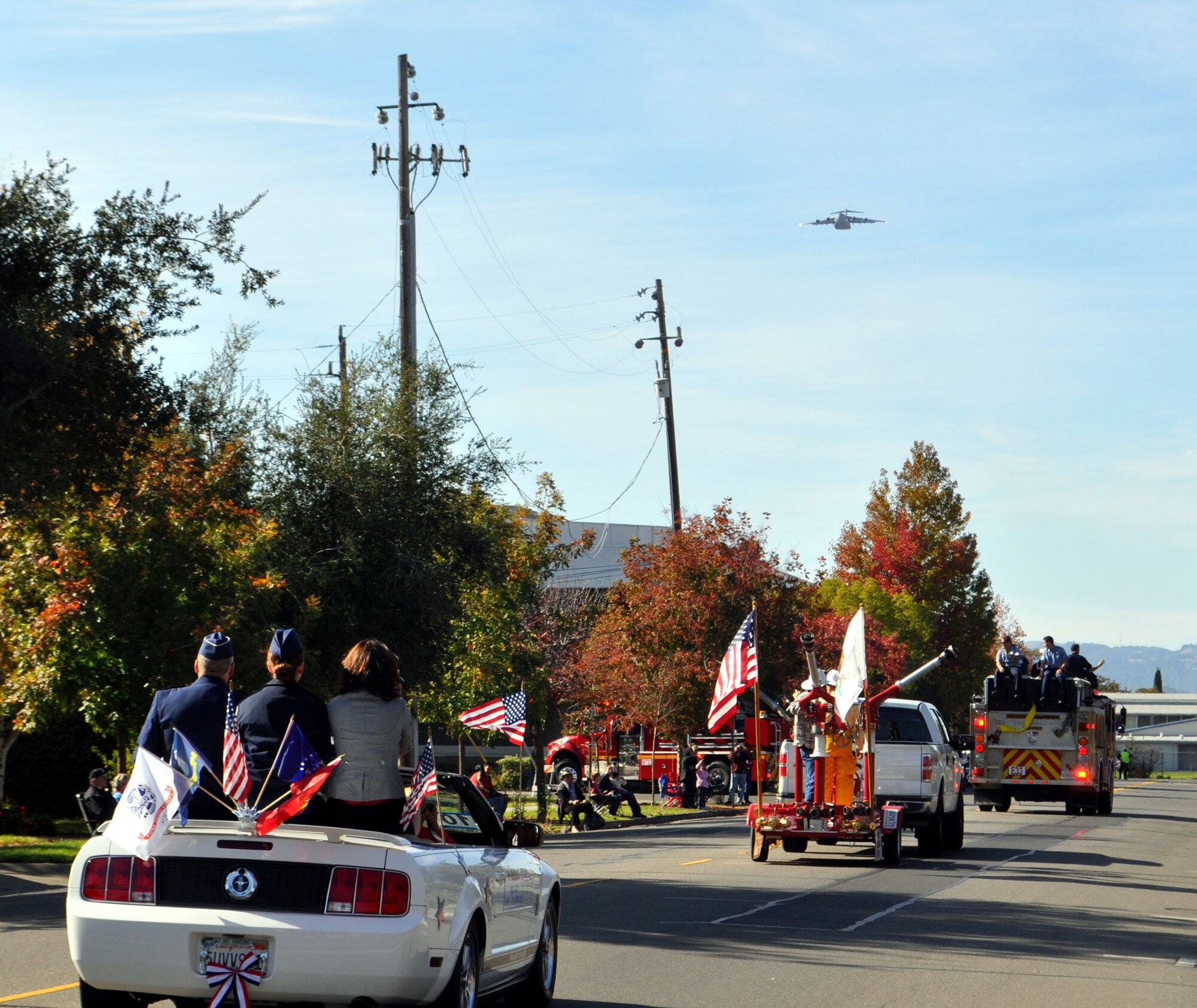 TRAVIS AIR FORCE BASE, Calif. -- The 2012 Fairfield Veterans Day stepped off as a Travis AFB C-17 flew down the parade route, gently banked to the left, and disappeared. Riding underneath the flyover, in the white convertible, was Parade Grand Marshal, Brig. Gen. John C. Flournoy, Jr., with his daughter, Emily, center, and wife, Anne. At Travis, he commands the largest Reserve associate wing in the Air Force, the 349th Air Mobility Wing. (U.S. Air Force photo/Senior Master Sgt. Ellen L Hatfield)