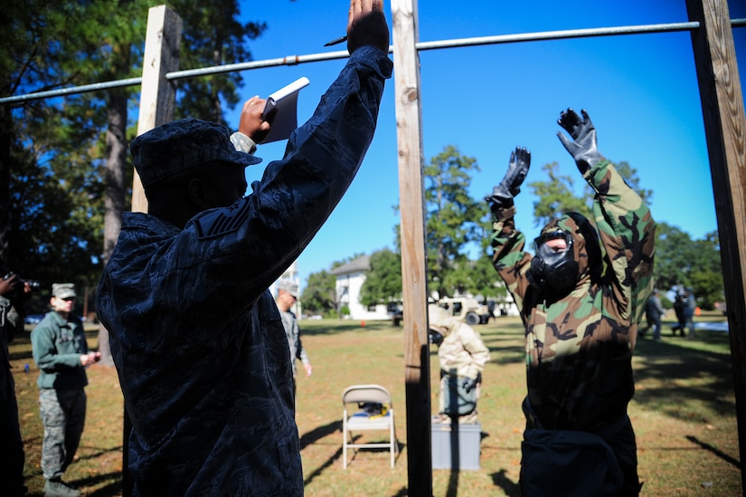 Master Sgt. Thomas Coney shows Senior Airman Angela Setliff how to decontaminate herself in a decontamination station during a Chemical, Biological, Radiological, Nuclear, Explosives Defense Survival Skills training scenario Nov. 8, 2012, at Joint Base Charleston - Air Base, S.C.  Coney and Setliff are assigned to the 1st Combat Camera Squadron. 1st CTCS participates in various types of training to stay mission ready as they often document first responders in humanitarian relief efforts and disasters. (U.S. Air Force photo by/Staff Sgt. Rasheen Douglas)