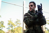 Senior Airman James Richardson, 1st Combat Camera Squadron photographer, simulates wiping decontaminating his gloves during  a Chemical, Biological, Radiological, Nuclear, Explosives Defense Survival Skills training scenario Nov. 8, 2012, at Joint Base Charleston - Air Base, S.C.  1st CTCS participates in various types of training to stay mission ready as they often document first responders in humanitarian relief efforts and disasters. (U.S. Air Force photo by/Staff Sgt. Rasheen Douglas)