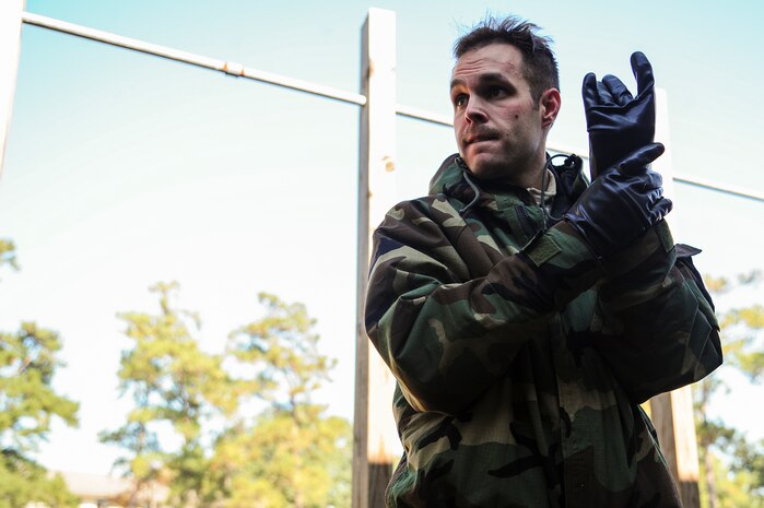 Senior Airman James Richardson, 1st Combat Camera Squadron photographer, simulates wiping decontaminating his gloves during  a Chemical, Biological, Radiological, Nuclear, Explosives Defense Survival Skills training scenario Nov. 8, 2012, at Joint Base Charleston - Air Base, S.C.  1st CTCS participates in various types of training to stay mission ready as they often document first responders in humanitarian relief efforts and disasters. (U.S. Air Force photo by/Staff Sgt. Rasheen Douglas)