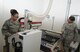 Staff Sgt. Joy Victoria and Staff Sgt. Maria Cook, use the milling machine to cut arch support inserts, Oct. 9 at the David Grant Medical Center brace shop. (US Air Force photo/Staff Sgt. Liliana Moreno)
