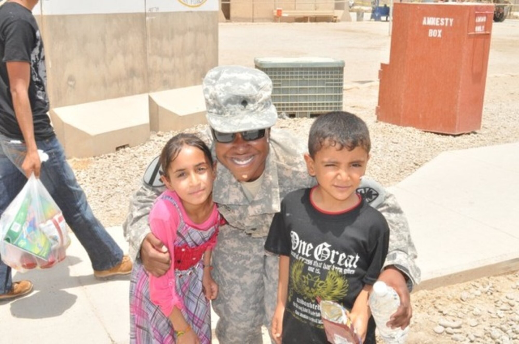 U.S. Army Sgt. LaRita Fullwood, 7th Sustainment Brigade chaplain assistant noncommissioned officer in charge, stands with Iraqi children at Joint-base Balad, Iraq. Fullwood and other Soldiers participated in a mentoring program “Iraqi Kids Day” with the 53rd Transportation Battalion. (U.S. Army courtesy photo/Released)