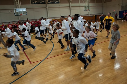 Basketball players from Ohio State, Notre Dame and Marquette University warm up with military children during a Hoops from Home Clinic Nov. 8, 2012, at Joint Base Charleston, S.C. Hoops from Home is a non-profit organization providing a basketball camp/clinic experience to the children of military families across the world. It provides the children with an opportunity to work with players and coaches and highlight the benefits of team sports, physical activity and commitment. (U.S. Air Force photo/Airman 1st Class Ashlee Galloway)