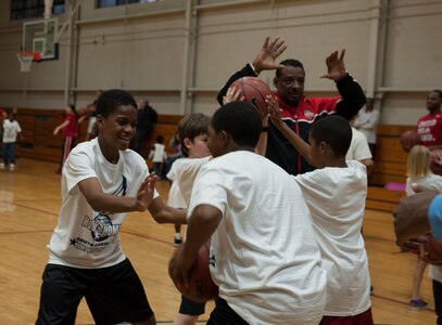 Basketball players from Ohio State, Notre Dame and Marquette University have military children practice defense moves during a Hoops from Home Clinic Nov. 8, 2012, at Joint Base Charleston, S.C. Hoops from Home is a non-profit organization providing a basketball camp/clinic experience to the children of military families across the world. It provides the children with an opportunity to work with players and coaches and highlight the benefits of team sports, physical activity and commitment. (U.S. Air Force photo/Airman 1st Class Ashlee Galloway)