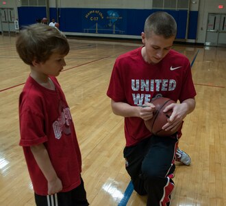 Owen Combs, son of Master Sgt. Jason Combs, 437th Operations Group, receives an autograph from Jacob Lorbach from Ohio State, after a Hoops from Home Clinic Nov. 8, 2012, at Joint Base Charleston, S.C. Hoops from Home is a non-profit organization providing a basketball camp/clinic experience to children of military families across the world. It provides the children with an opportunity to work with players and coaches and highlight the benefits of team sports, physical activity and commitment. (U.S. Air Force photo/Airman 1st Class Ashlee Galloway)