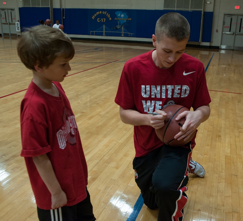 Owen Combs, son of Master Sgt. Jason Combs, 437th Operations Group, receives an autograph from Jacob Lorbach from Ohio State, after a Hoops from Home Clinic Nov. 8, 2012, at Joint Base Charleston, S.C. Hoops from Home is a non-profit organization providing a basketball camp/clinic experience to children of military families across the world. It provides the children with an opportunity to work with players and coaches and highlight the benefits of team sports, physical activity and commitment. (U.S. Air Force photo/Airman 1st Class Ashlee Galloway)