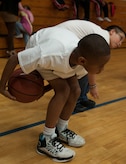 Richard Gilliard, son of Ingrid Gilliard, 437th Aerial Port Squadron, practices maneuvering a basketball during a Hoops from Home Clinic Nov. 8, 2012, at Joint Base Charleston, S.C. Hoops from Home is a non-profit organization providing a basketball camp/clinic experience to children of military families across the world. It provides the children with an opportunity to work with players and coaches and highlight the benefits of team sports, physical activity and commitment. (U.S. Air Force photo/Airman 1st Class Ashlee Galloway)