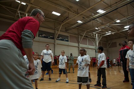 Basketball players from Ohio State, Norte Dame and Marquette University show military children how to properly shoot a basket during the Hoops from Home Clinic Nov. 8, 2012, at Joint Base Charleston, S.C. Hoops from Home is a non-profit organization providing a basketball camp/clinic experience to children of military families across the world. It provides the children an opportunity to work with players and coaches and highlight the benefits of team sports, physical activity and commitment. (U.S. Air Force photo/Airman 1st Class Ashlee Galloway)