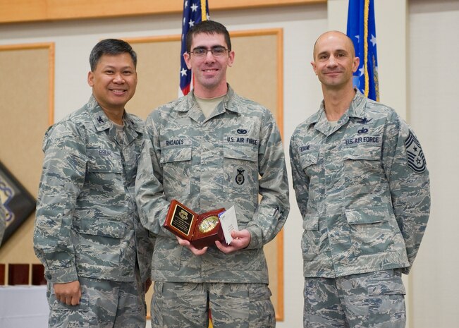 Airman 1st Class Jonathan Rhoades, 341st Security Forces Squadron, center, was named the 341st Missile Wing's Honor Guard Member of the Quarter for the third quarter of 2012.  Shown presenting the award are Col. H.B. Brual, 341 MW commander, and Chief Master Sgt. Frank Fidani, 341 MW command chief.  The presentation was made at the Wing Quarterly Awards breakfast held Oct. 16 at the Grizzly Bend.  (U.S. Air Force photo/ Beau Wade)