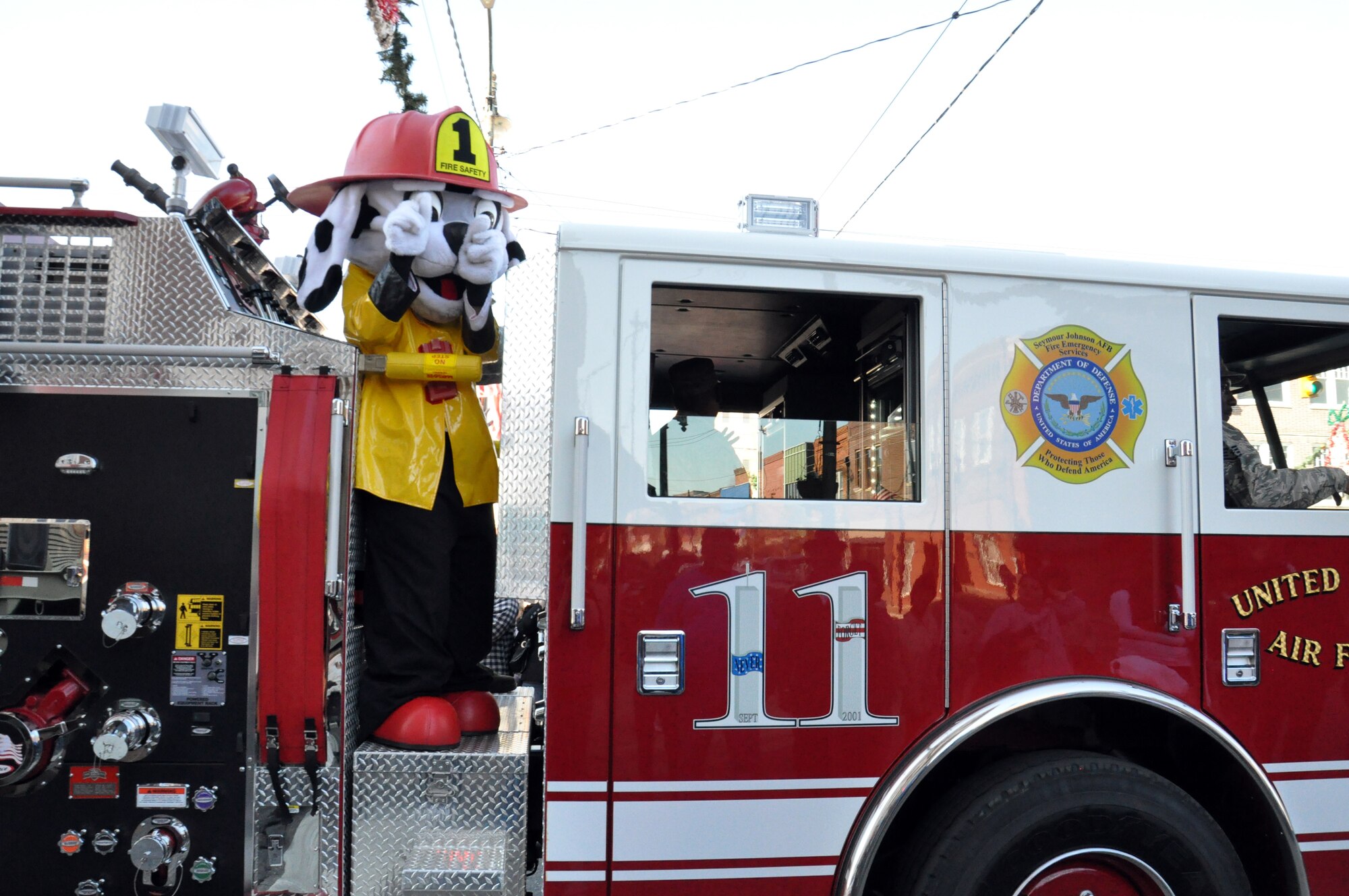 Sparky, 4th Civil Engineer Squadron fire prevention mascot, waves to children and families during the Wayne County Veteran’s Day Parade in Goldsboro, N.C., Nov. 10, 2012. Sparky and the 4th CES fire emergency services flight were one of several groups of Airmen from the base who participated in the parade. (U.S. Air Force photo/Airman 1st Class Mariah Tolbert/Released)