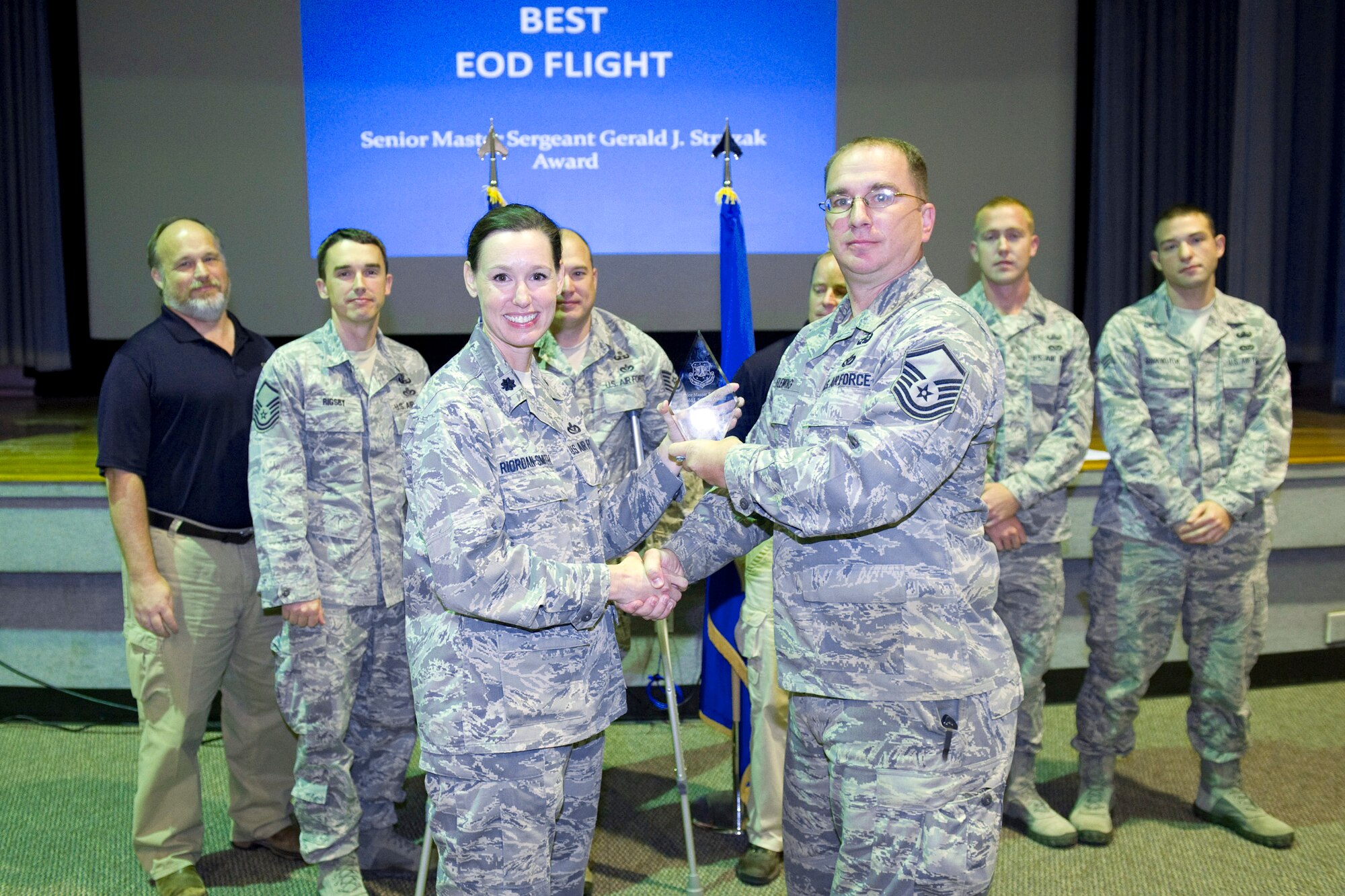 Master Sgt. Brian a. Fleming accepts the Senior Master Sgt. Stryzak Award for Outstanding EOD Flight presented by Lt. Col. Susan Riordan-Smith. 