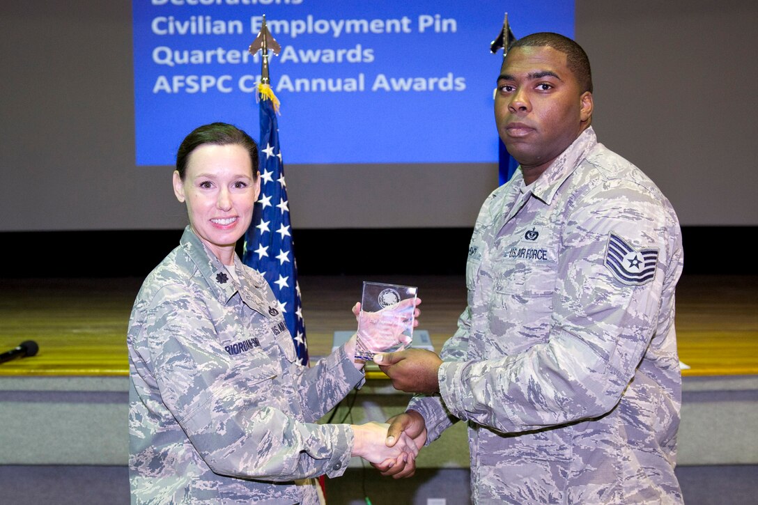 Lt. Col. Susan Riordan-Smith, commander, 45th Civil Engineer Squadron, presents the Volunteer of the Quarter Award to Tech Sgt. Dayrone Henry.