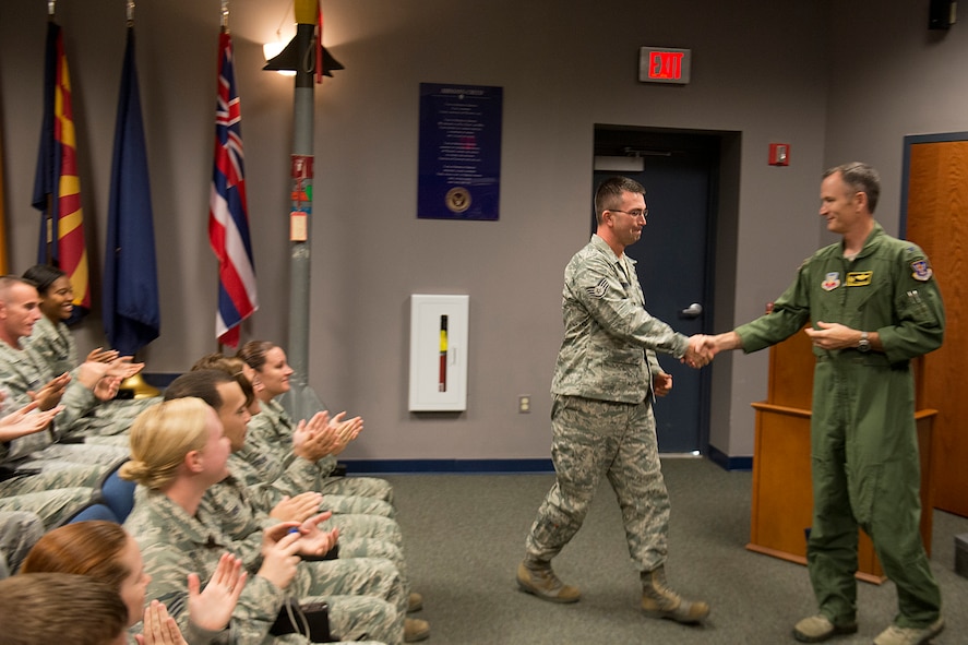 U.S. Air Force Staff Sgt. Michael Youngblood, 23d Force Support Squadron Senior Airman Jason D. Cunningham Airman Leadership School instructor, shakes hands with Col. Billy Thompson, 23d Wing commander, after being notified of his promotion to technical sergeant Nov. 14, 2012, at Moody Air Force Base, Ga. Youngblood was promoted under the Stripes for Exceptional Performers program. (U.S. Air Force photo by Staff Sgt. Jamal D. Sutter/Released) 