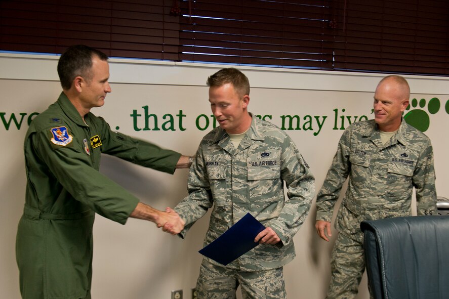 Newly promoted U.S. Air Force Tech. Sgt. Cody Murray, 23d Maintenance Group HH-60 quality assurance inspector, shakes hands with Col. Billy Thompson, 23d Wing commander, after receiving his new rank Nov. 13, 2012, at Moody Air Force Base, Ga. Murray was promoted under the Stripes for Exceptional Performers program. (U.S. Air Force photo by Staff Sgt. Jamal D. Sutter/Released) 