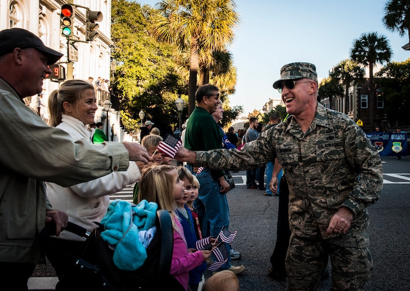 Chief Master Sgt. Earl Hannon, 628th Air Base Wing command chief, passes out American flags to civilians and veterans during the Veterans Day Parade Nov. 10, 2012, in Charleston, S.C. More than a hundred Airmen and Sailors from Joint Base Charleston marched in the parade, which traveled through the streets of historic downtown Charleston. (U.S. Air Force photo/ Senior Airman Dennis Sloan)