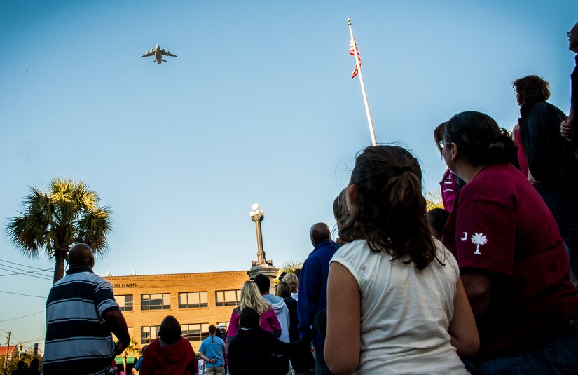 Civilians and veterans look skyward as a C-17 Globemaster III from Joint Base Charleston flies over downtown Charleston, S.C, to start the Veterans Day Parade Nov. 10, 2012. More than a hundred Airmen and Sailors from JB Charleston marched in the parade, which traveled through the streets of historic downtown Charleston. (U.S. Air Force photo/ Senior Airman Dennis Sloan)