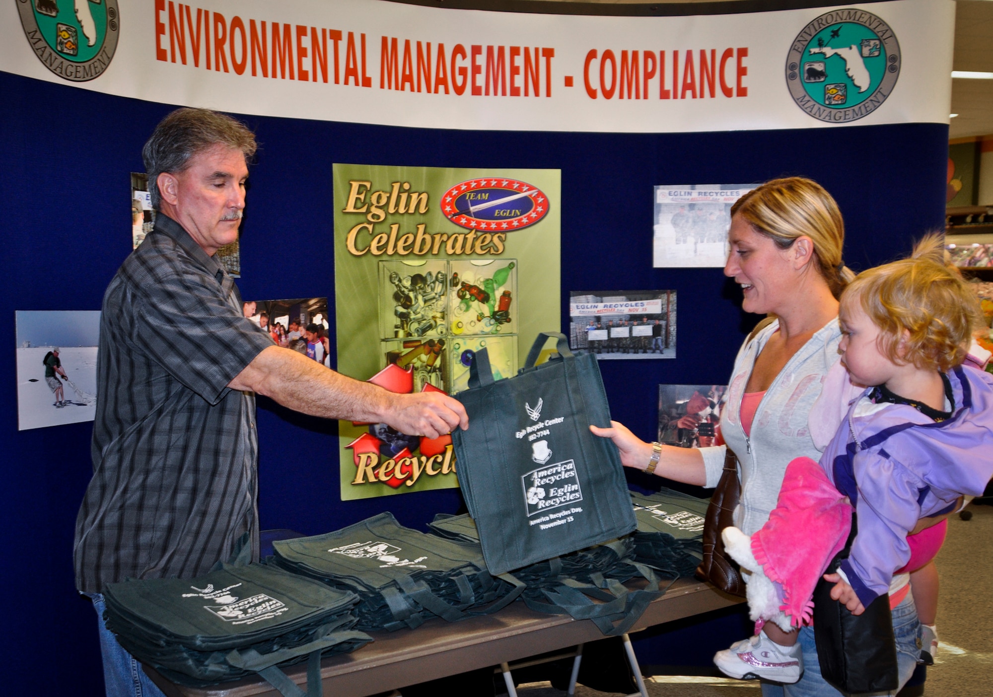 Michael Vannoy, the 96th Civil Engineer Group Qualified Recycling Program manager, hands out reusable shopping bags at the Eglin Commissary, Nov. 14, in celebration of America Recycles Day.  A 5K Fun Run/Walk will also be part of the festivities Nov. 16.  The run is begins at 7:30 a.m. at CE pavilion. (U.S. Air Force photo/Mike Spaits)