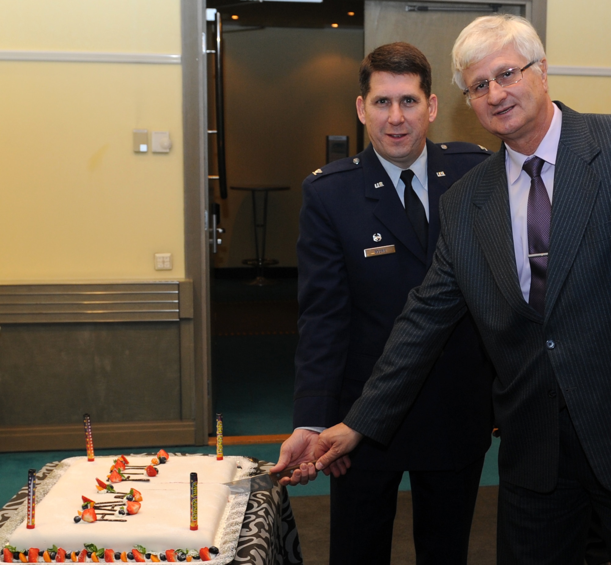 Col. Keith Boone, Heavy Airlift Wing Commander, and Dr. Gyula Keszthelyi, the chief of host nation support with the Hungarian MOD, cut a cake commemorating the achievement of full operational capability for the Heavy Airlift Wing at Papa AB, Hungary. The ceremony occurred at a Strategic Airlift Capability Steering and Program Board meeting Nov. 14, 2012, in Tallinn, Estonia. (U.S. Air Force photo/Capt. Michael Hertzog)