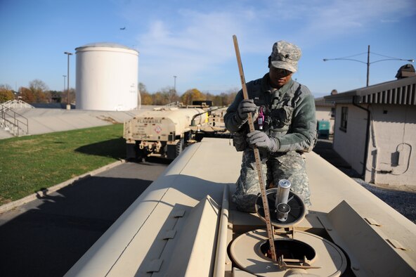 Spc. Jocelyn Griffen, 710th Brigade Support Battalion fueler, from Lafayette, La., gauges the tanks of a Heavy Expanded Mobility Tactical Truck to determine how much fuel is currently in the tank Nov. 6, 2012, at Joint Base McGuire-Dix-Lakehurst, N.J. Soldiers from the 710th BSB out of Fort Drum, N.Y., worked with Airmen from the 87th Logistics Readiness Squadron Fuels Management Flight, to fill five HEMTT with fuel to be delivered to regions around New York and New Jersey for Hurricane Sandy relief efforts.  (U.S. Air Force photo/2nd Lt. David J. Murphy)