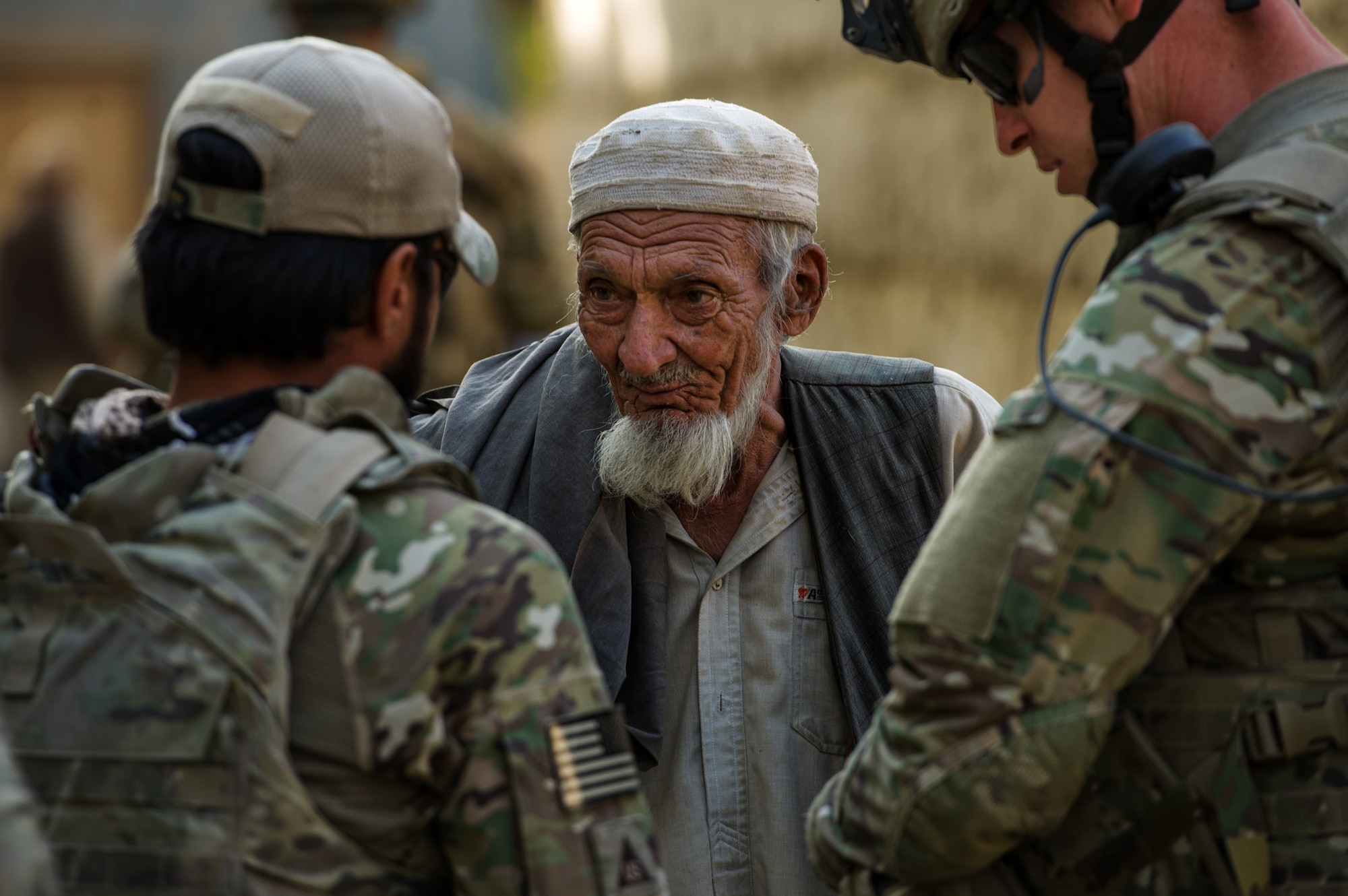 Alex Unguist, left, interpreter, and U.S. Air Force Master Sgt. Richard Holder, right, both 455th Expeditionary Security Forces Squadron, Reaper Team, talk with the village elder Oct. 25, 2012, outside Bagram Airfield, Afghanistan. Reaper teams regularly perform counter-insurgency missions, visiting numerous villages within the Bagram district where they meet local elders and children. These visits help build a good working relationship with the local villagers, along with providing additional safety and security to the area. Holder hometown is Knoxville, Tenn. (U.S. Air Force photo/ Staff Sgt. Jonathan Snyder)(RELEASED)