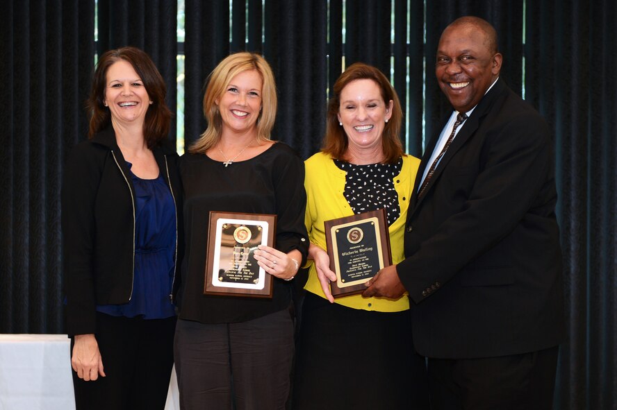Victoria Bailey (center left), local trophy and engraving shop owner and Pam Caine, spouse of Col. Scott Caine, 9th Air Force vice commander both receive appreciation plaques for their participation in the Principal for a Day program at Shaw Heights Elementary School, Swan Lake Visitor Center, S.C., Nov. 13, 2012. The Principal for a Day program afforded Bailey and Caine an opportunity to experience the challenges and triumphs of being the school’s principal for a day. Both Bailey and Caine were recognized for their participation in the program during an honorary banquet held to thank all the local leaders and military members for their participation in the program and community. (U.S. Air Force photo by Airman 1st Class Daniel Blackwell/Released)
