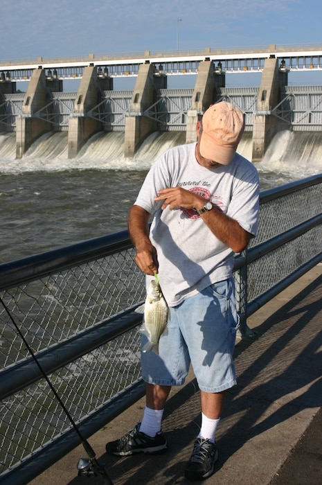Fisherman catches a white bass near the spillway at Gavins Point Project.