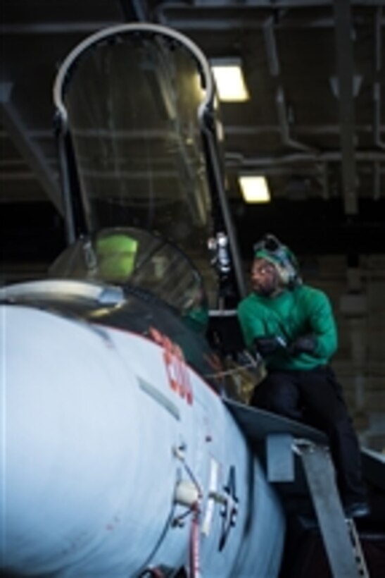 U.S. Navy Petty Officer 3rd Class Daryll Williams opens the canopy of an F/A-18E Super Hornet in the hanger bay of the aircraft carrier USS Nimitz (CVN 68) as the ship operates in the Pacific Ocean on Nov. 12, 2012.  Williams is a Navy aviation structural mechanic attached to Strike Fighter Squadron 154.  