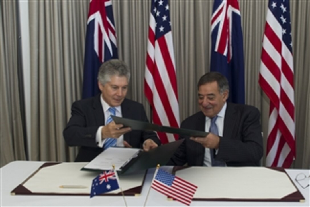 Australian Minister for Defence Stephen Smith, left, and Secretary of Defense Leon E. Panetta exchange folders as they sign a memorandum of understanding during the Australia-U.S. ministerial consultations in Perth, Australia, on Nov. 14, 2012.  