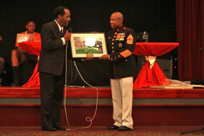 Eugene Clark, Youth and Teen Center director, presents Sgt. Maj. Gerard J. Calvin, Mini Marine Corps Ball guest speaker and Marine Aviation Logistics Squadron 12 sergeant major, with a plaque at the Club Iwakuni ballroom during the Mini Marine Corps Ball here Oct. 26, 2012. 