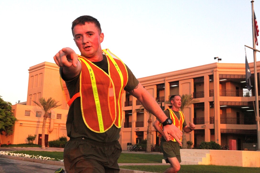 Sgts Cody Marshall and Matthew T. Madlem sprint ahead of the formation to direct traffic during the Marine Corps Birthday run on Naval Support Activity, Bahrain Nov 8.