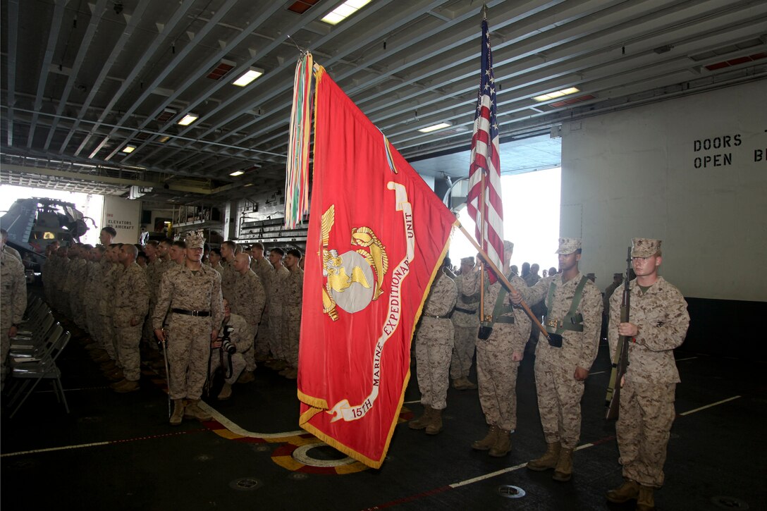 Marines with the 15th Marine Expeditionary Unit render honors during the playing of the national anthem at the 237th Marine Corps Cake Cutting Ceremony held in the hangar bay of the USS Peleliu, Nov. 10. The 15th MEU is deployed as part of the Peleliu Amphibious Ready Group as a theater reserve and crisis response force throughout U.S. Central Command and the U.S. 5th Fleet area of responsibility.