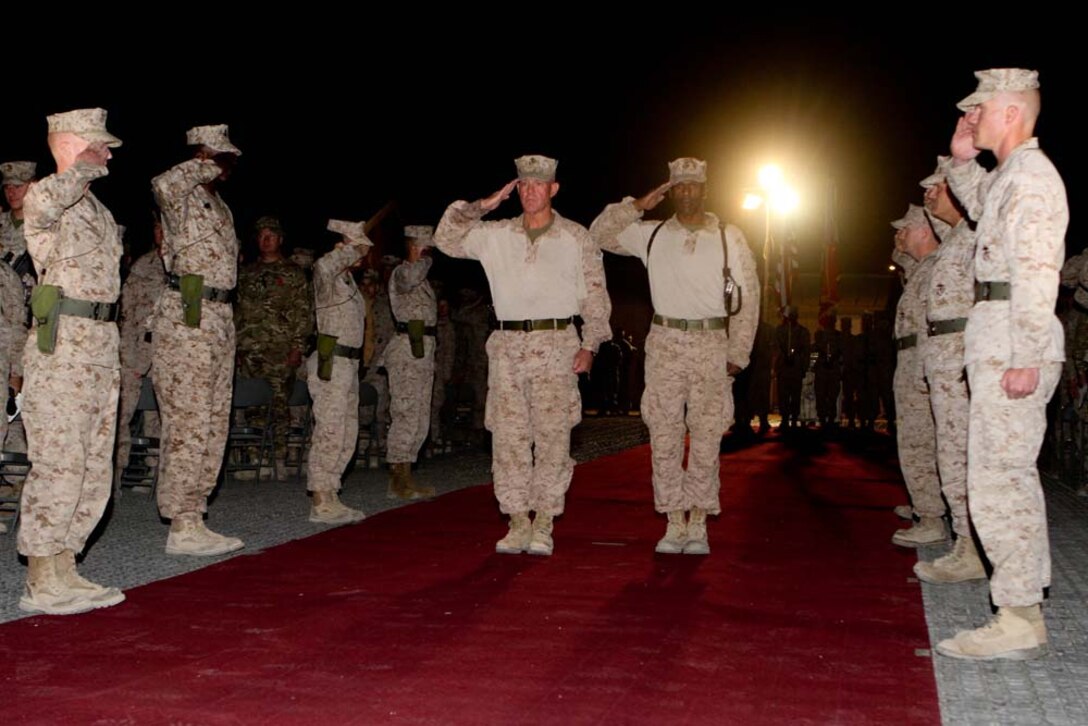 Major Gen. Charles M. Gurganus, Regional Command (Southwest) commanding general, and RC(SW) Sgt. Maj. Harrison Tanksley salute during the RC(SW) cake cutting ceremony at Camp Leatherneck, Nov. 10, 2012.
