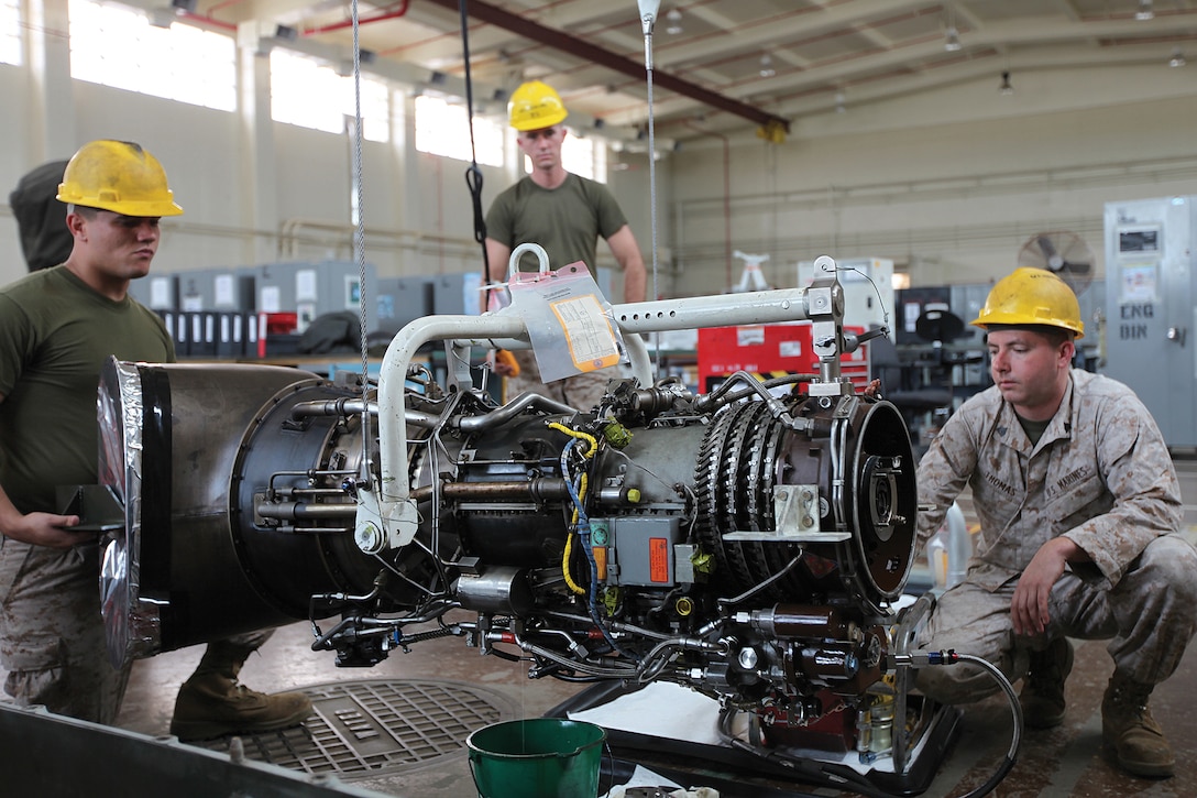 Marines drain lubricants from the engine of a CH-46E Sea Knight helicopter in preparation for storage Nov. 2 as part of the transition to the MV-22B Osprey at Marine Corps Air Station Futenma. The Marines are helicopter power plants mechanics with Marine Aviation Logistics Squadron 36, Marine Aircraft Group 36, 1st Marine Aircraft Wing, III Marine Expeditionary Force.