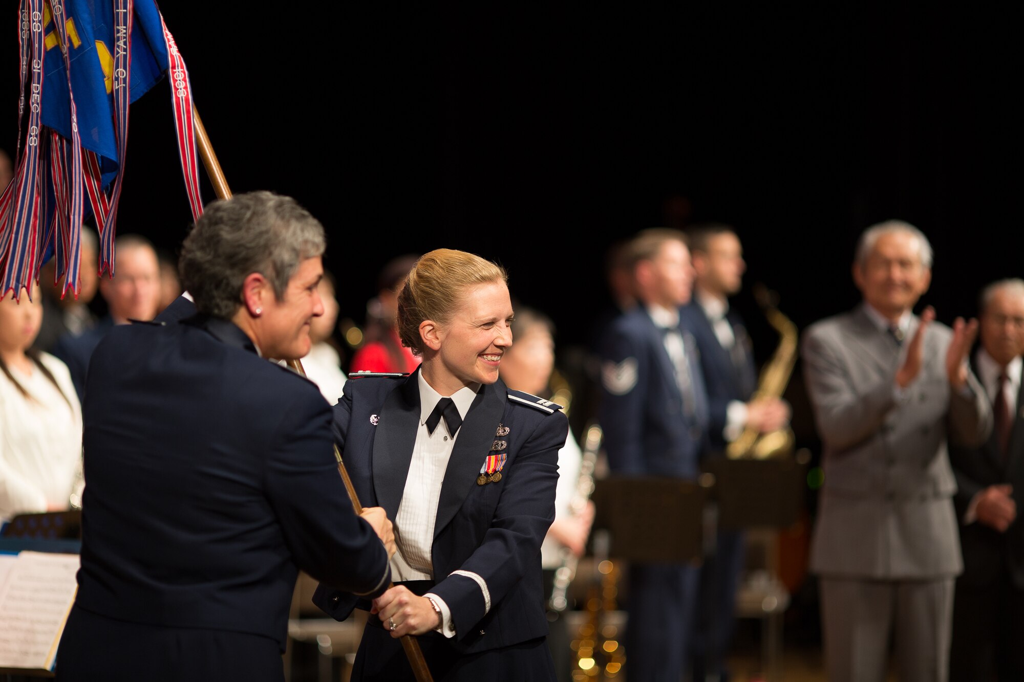 MIZUHO TOWN, Japan -- Col. Darlene Sanders, 374th Maintenance Group commander, passes the Pacific Air Forces Band guidon to Capt. Haley Armstrong, Band of the Pacific commander, during an assumption of command ceremony during the annual Goodwill Concert at the Mizuho Viewpark Sky Hall in Mizuho Town, Japan, Nov. 10, 2012. Armstrong assumed command following the band's previous commander Maj. Michael Willen. (U.S. Air Force photo/Staff Sgt. Josh Voyles)