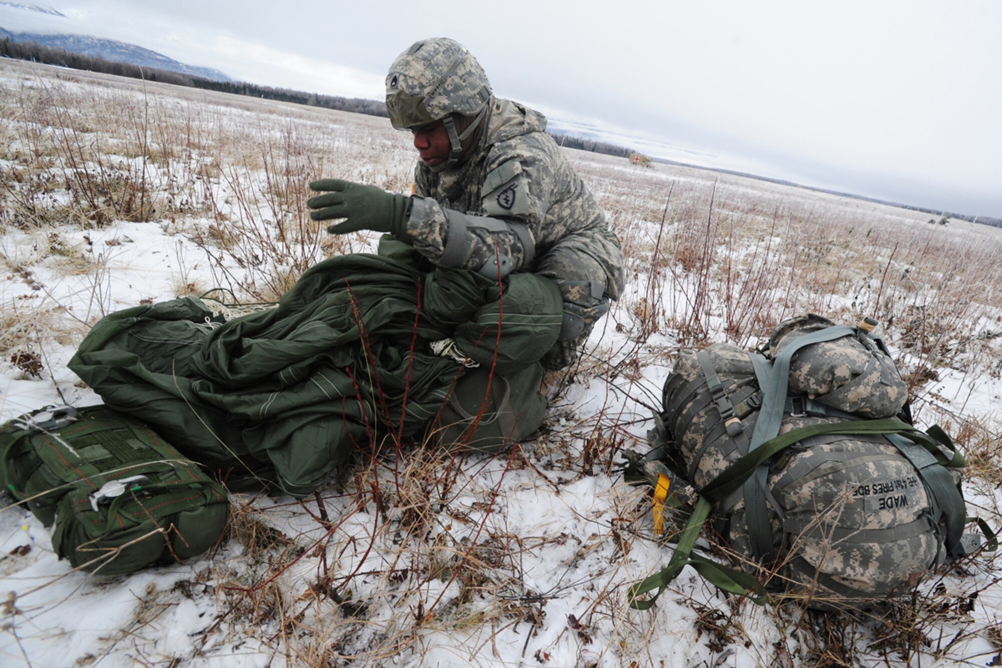 JOINT BASE ELMENDORF-RICHARDSON, Alaska -- U.S. Army Staff Sgt. Myron Wade, assigned to 2nd Battalion (Airborne) 377 Parachute Field Artillery Regiment, a native of St. Louis, Mo., packs his parachute in an aviator's kit bag after paratroopers of U.S. Army Alaska's 4th Brigade Combat Team (Airborne), 25th Infantry Division conduct a training parachute assault on Malamute Drop Zone on Joint Base Elmendorf-Richardson, Tuesday, Nov. 13, 2012.  The brigade recently returned from a ten-month tour in Afghanistan, and approximately 200 of the unit's Soldiers made the jump into their sub-arctic home installation. (U.S. Air Force photo by Justin Connaher)


