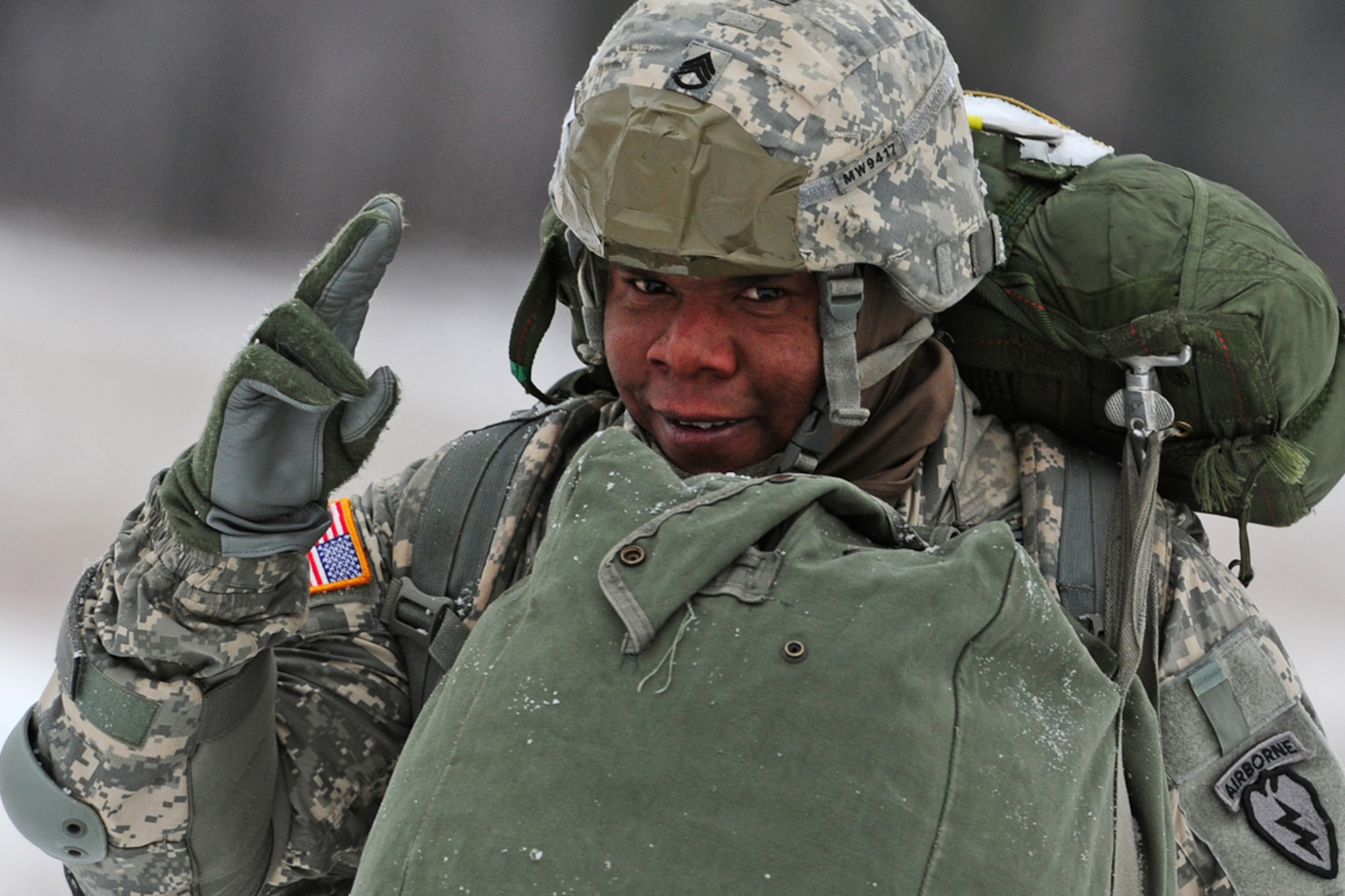 JOINT BASE ELMENDORF-RICHARDSON, Alaska -- U.S. Army Staff Sgt. Myron Wade, assigned to 2nd Battalion (Airborne) 377 Parachute Field Artillery Regiment, a native of St. Louis, Mo., waves to the camera as he walks to the rally point after paratroopers of U.S. Army Alaska's 4th Brigade Combat Team (Airborne), 25th Infantry Division conduct a training parachute assault on Malamute Drop Zone on Joint Base Elmendorf-Richardson, Tuesday, Nov. 13, 2012.  The brigade recently returned from a ten-month tour in Afghanistan, and approximately 200 of the unit's Soldiers made the jump into their sub-arctic home installation. (U.S. Air Force photo by Justin Connaher)
