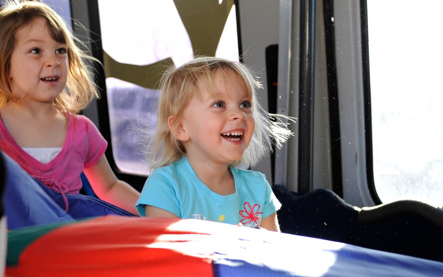 Hailey James (right), 3, helps Gabby Werdell (left), 4, lift up a colored tarp during a gymnastics class on the Tumbling Tots Tumble Bus at Ellsworth Air Force Base, S.D., Nov. 7, 2012. The class, taught by Katie Welch, is currently being offered to all Ellsworth children ages 2 to 6 in an effort to help them get a head start on an active lifestyle. (U.S. Air Force photo by Airman Ashley J. Woolridge/Released)