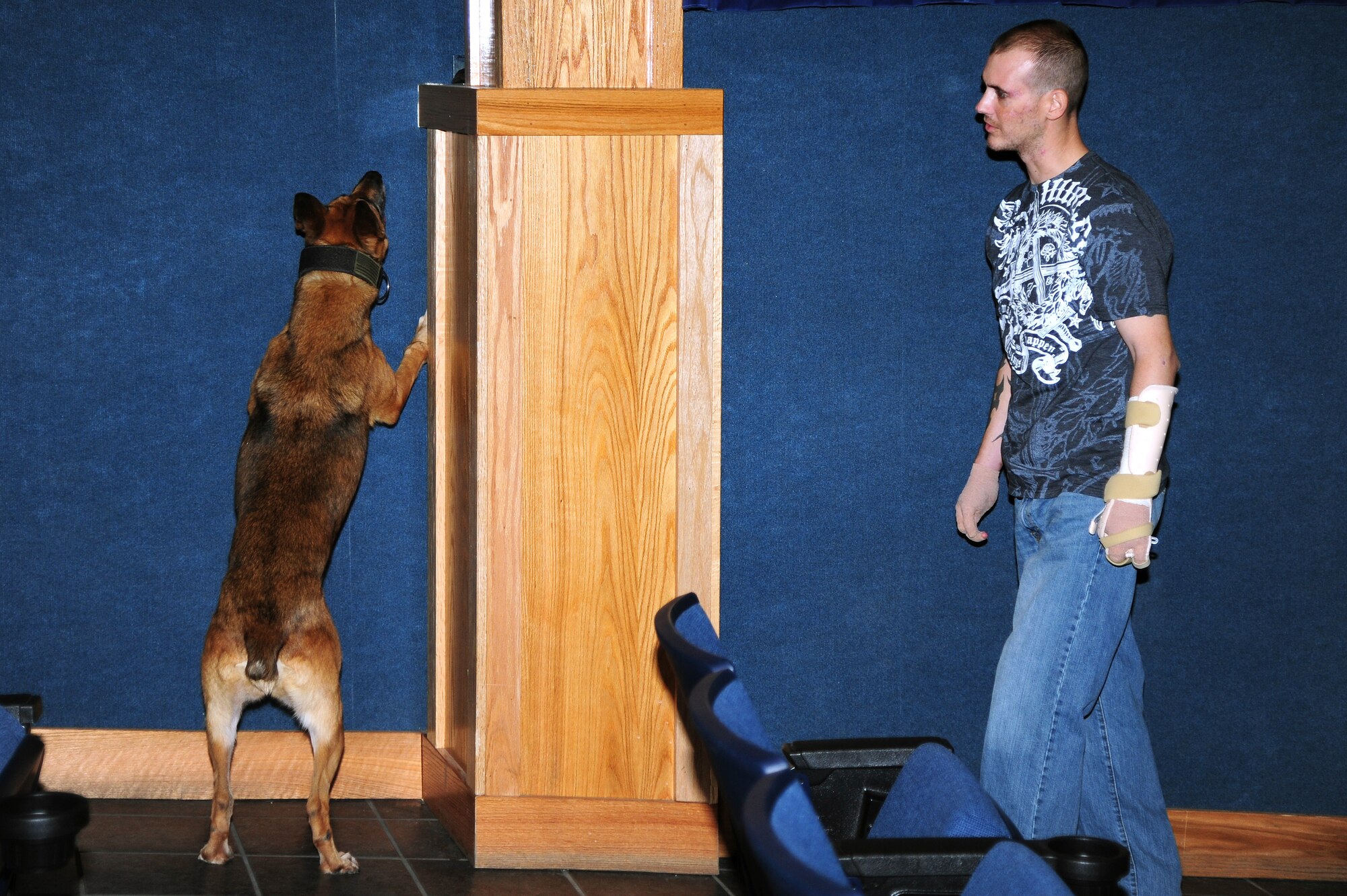 Staff Sgt. Leonard Anderson, 59th Patient Squadron, Lackland Air Force Base, Texas, conducts detection training with Azza, 354th Security Force Squadron military working dog, at the base theater Oct. 17, 2012, Eielson Air Force Base, Alaska. Anderson, a former 354th SFS MWD handler, returned to Eielson where he was reunited with Azza after months of recovery following an attack during his deployment to Afghanistan. (U.S. Air Force photo/Airman 1st Class Zachary Perras)