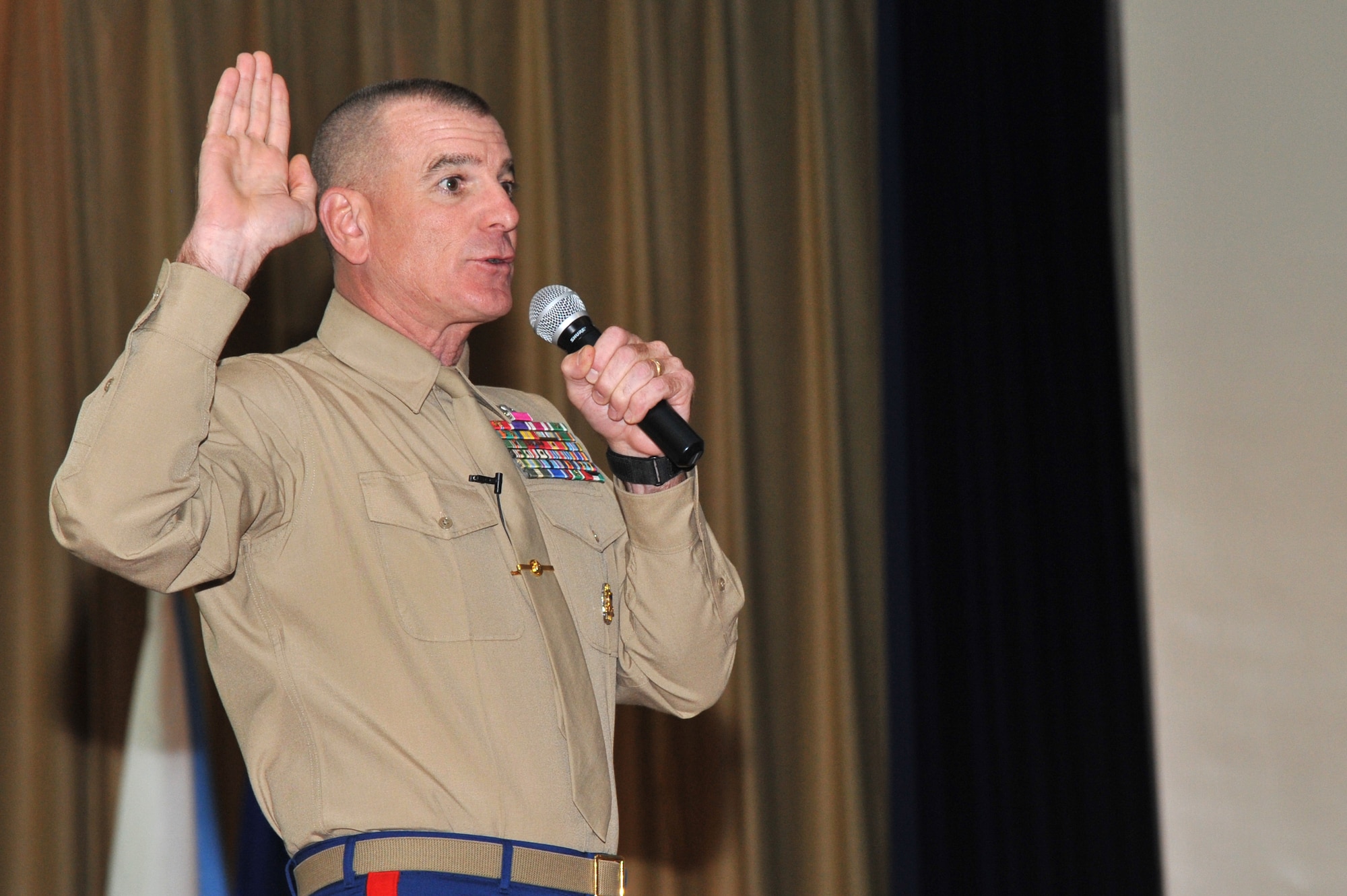 Marine Sgt. Maj. Bryan Battaglia, senior enlisted advisor to the chairman of the Joint Chiefs of Staff, addresses a packed house of Airmen and Sailors during an enlisted call Tuesday. Battaglia urged service members to renew their commitment to the profession of arms, adding that the oath of enlistment taken by the most senior NCO in the Defense Department to the most junior Airman in the room is identical. During the call, the SEAC coined 22 Luke Airman for their dedication to excellence. (U.S. Air Force photo by Senior Airman Sandra Welch)