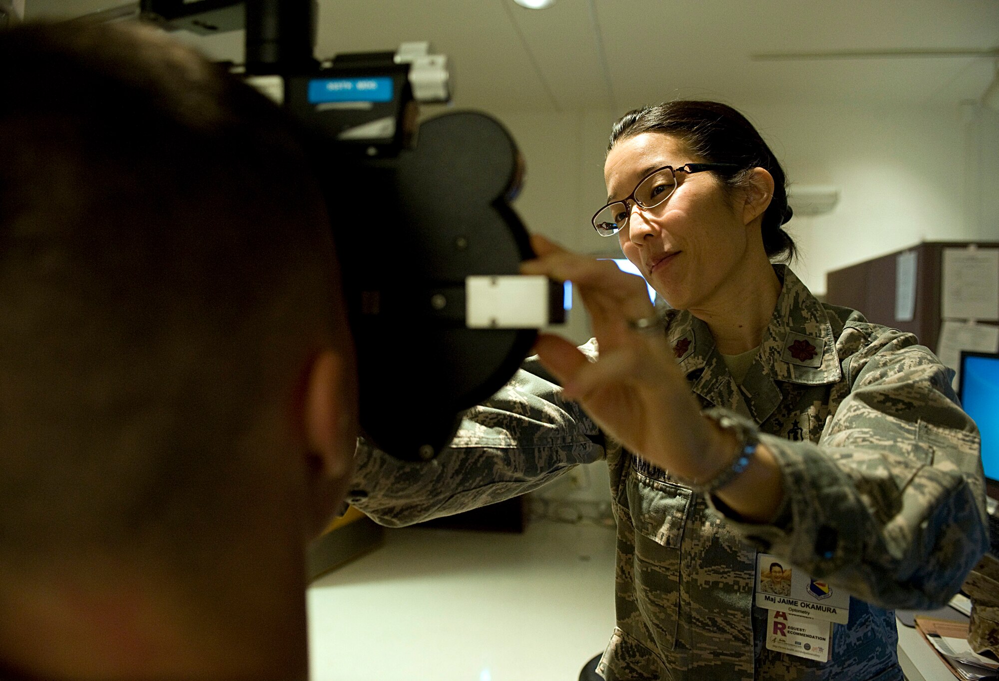 U.S. Air Force Maj. Jaime Okamura, 355th Aerospace Medicine Squadron optometrist, conducts an eye exam for a member of the U.S. Marine Corps on Davis-Monthan Air Force Base, Ariz., Nov. 6, 2012. The 355th AMDS provides medical services to all military members assigned to D-M. (U.S. Air Force photo by Senior Airman Timothy Moore/Released)