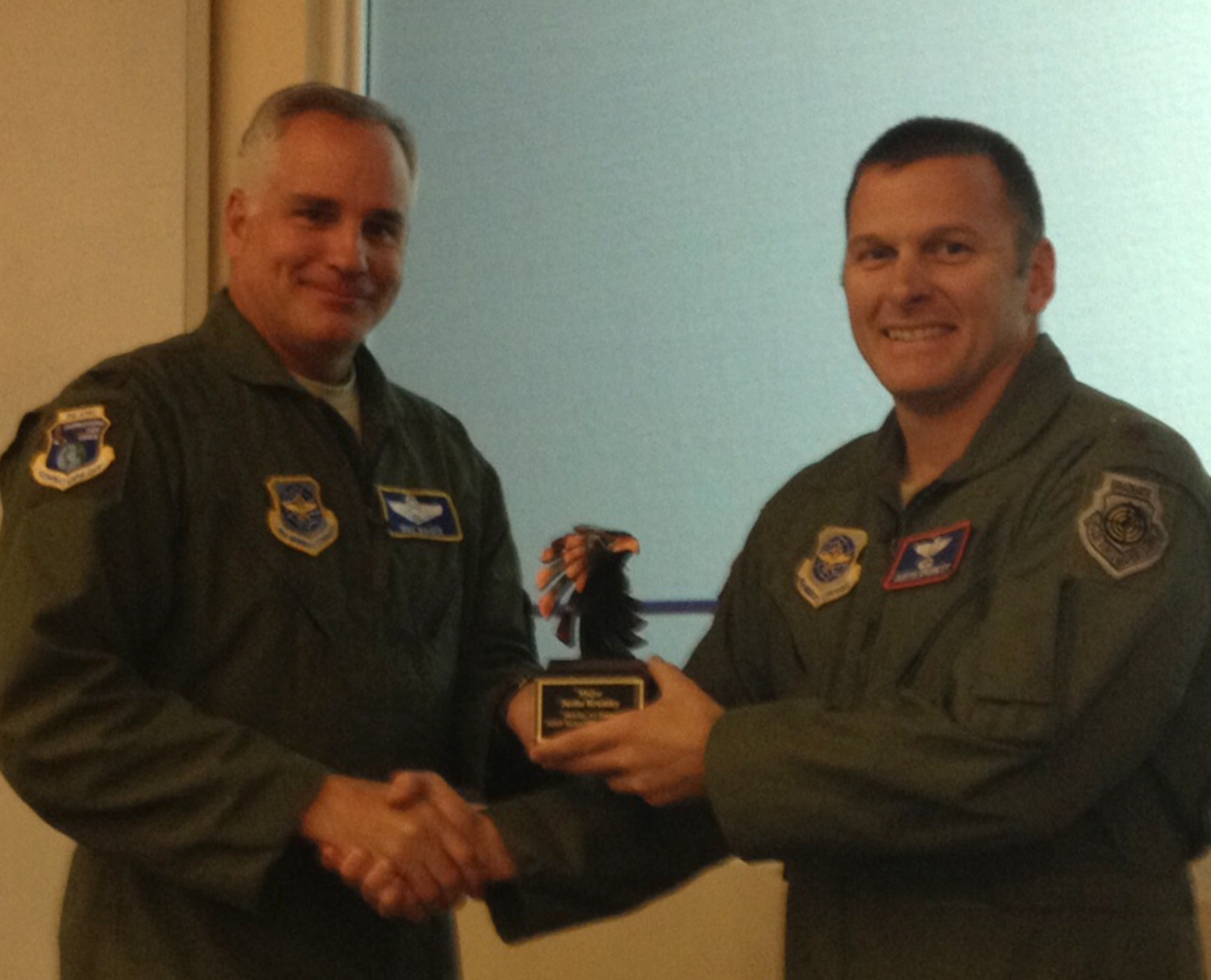Col. Michael Bauer, Air Mobility Command combat operations division chief, presents Maj. Justin Brumley, 317th Airlift Group, the Mobility Air Forces 2011 Tactician of the Year award Nov. 8, 2012, at Rosecrans Air National Guard Base, Mo. Each year, MAF officials recognize tacticians for their outstanding capabilities during airdrop and air medical evacuation missions based on how well they were accomplished. Tech. Sgt. Ryan Crumrine, 317th AG, was also named MAF 2011 Tactician of the Year, but was unable to attend the ceremony due to a deployment.(Courtesy photo)