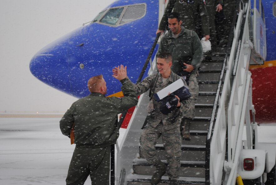 1st Lt. Lee Feldhausen, 341st Operations Support Squadron ICBM instructor combat crew commander, high-fives Staff Sgt. Dajon Begin, 341st Missile Maintenance Squadron missile communications team chief, upon arrival at Holman Aviation on Nov. 8. Behind him is his teammate, Staff Sgt. Mark Montemayor, 341st MMXS missile communications member. Begin and Montemayor earned the title of Best ICBM Missile Communications Team in the annual Global Strike Challenge and contributed to the Blackburn Trophy, which was awarded to the 341st Missile Wing for Best ICBM Maintenance Group. (U.S. Air Force photo/Airman 1st Class Katrina Heikkinen)
