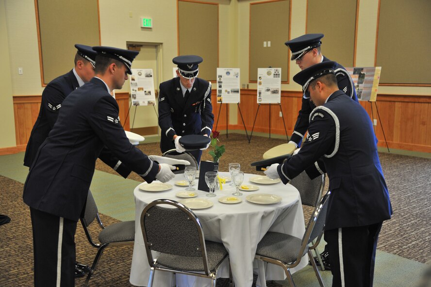 Members of Malmstrom's Honor Guard place service caps representing the five branches of the military on empty plates at the POW/MIA table to start Saturday's formal Welcome Home ceremony in honor of community Korean and Vietnam War veterans. (U.S. Air Force photo/John Turner)