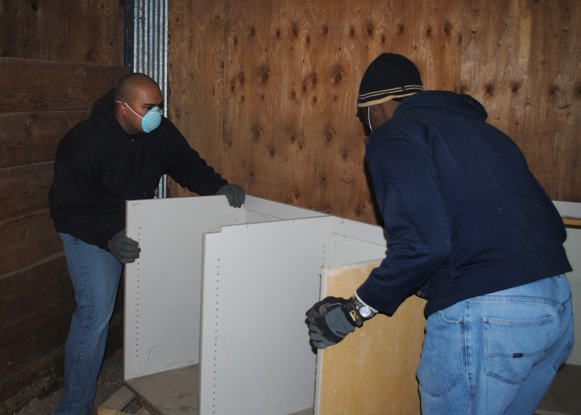 2nd Lt. Troy Meno, 10th Missile Squadron deputy combat crew commander (left), and Lt. Col. Demetrius Walters, 10th MS commander, carry shelves into an empty room at Eagle Mount on Nov. 8.  (U.S. Air Force photo/Airman 1st Class Cortney Paxton)
