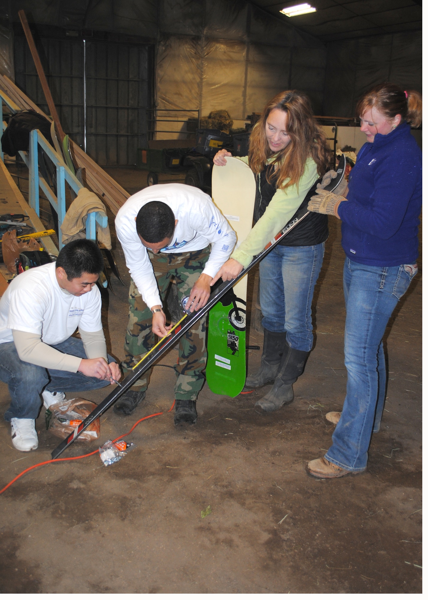 Stephanie Richardson, Eagle Mount program coordinator (far right), and Jenny Gooldy, Eagle Mount certified riding instructor, show 2nd Lts. Tony Onitsuka, 10th Missile Squadron member (far left), and Kiefer Caplan, 10th MS deputy combat crew commander, how long to make a ski before they cut it to be used in a project for Eagle Mount skiing activities.  Eagle Mount is a non-profit organization that helps people with disabilities of all kinds improve their quality of life.  (U.S. Air Force photo/Airman 1st Class Cortney Paxton)