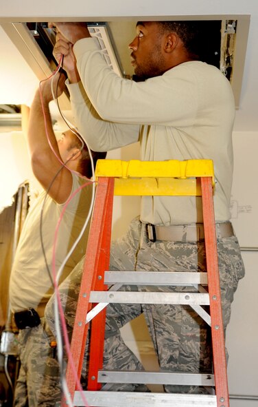Airman 1st Class Ravon McCoy, 2nd Civil Engineer Squadron electrical systems apprentice, runs 12-gauge wires through a panel on Barksdale Air Force Base, La., Nov. 14. McCoy is helping to restore power in some of the dorms that had water damage. (U.S. Air Force photo/Senior Airman Kristin High)(RELEASED)